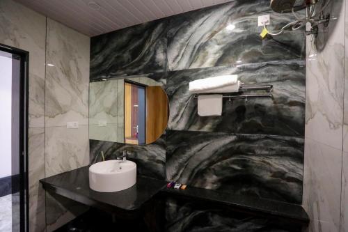 a bathroom with a sink and a marble wall at Nautical 9 Beach Retreat in Kundapur