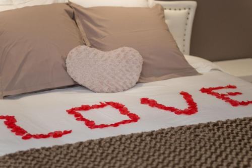 a bed with two hearts spelled out with red flowers at Séjour romantique, Massif central in Bort-les-Orgues