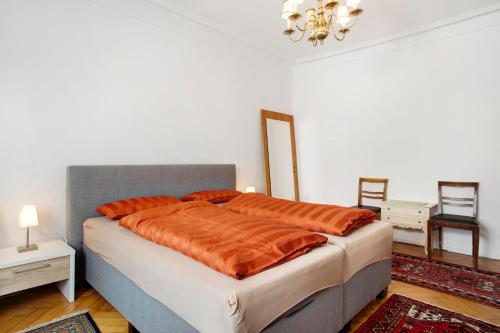 a bedroom with a large bed with orange sheets at Siravit Am See in Friedrichshafen