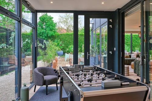 a glass room with a large chess board on a table at Extraordinaire Villa 5 étoiles 12 personnes 7 min Lille in Marcq-en-Baroeul