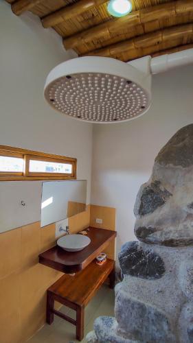 un bagno con lavandino e grande roccia di Seaside Bungalows a Máncora