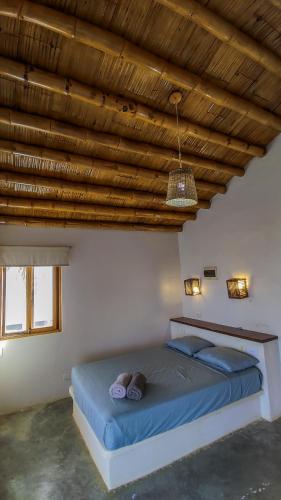 een bed in een kamer met een houten plafond bij Seaside Bungalows in Máncora