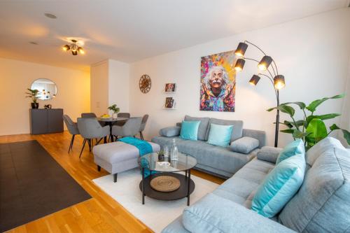 ein Wohnzimmer mit einem blauen Sofa und einem Tisch in der Unterkunft Special EiNSTEiN II Apartment Basel, Messe Kleinbasel 10-STAR in Basel