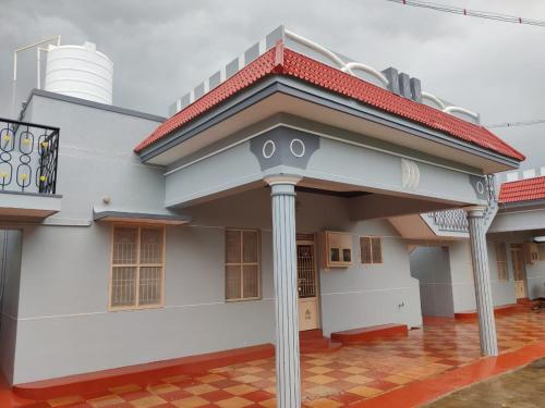una gran casa blanca con techo rojo en ARUNACHALA HOUSES, en Tiruvannāmalai