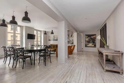 une salle à manger et un salon avec une table et des chaises dans l'établissement Saint-Honoré Luxurious 2 Bedrooms apartment 120m2, à Paris