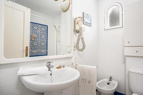 uma casa de banho branca com um lavatório e um WC em Reliquia 3 em Novo Sancti Petri