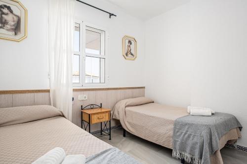 a room with two beds and a window at Reliquia 3 in Novo Sancti Petri