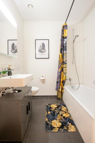 a bathroom with a sink and a tub and a toilet at Special EiNSTEiN II Apartment Basel, Messe Kleinbasel 10-STAR in Basel