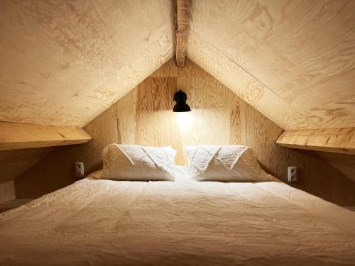 - un lit avec deux oreillers dans l'établissement Bayda's Tiny House, à Sprimont