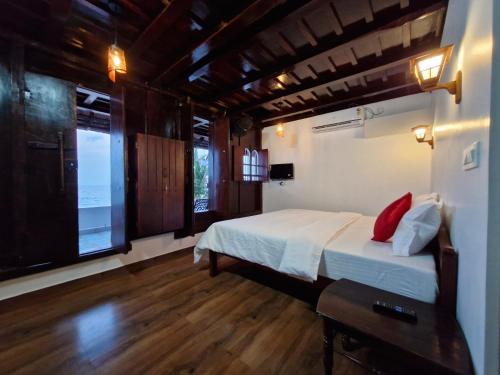 a bedroom with a bed and a large window at Seabreeze Marari in Alleppey