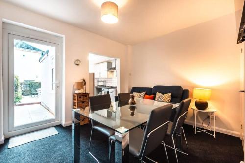 a dining room with a glass table and chairs at Modern House in Central Southampton with Private Off-Road Parking - Newly Refurbished - Great for Contractors, Friends & Families in Southampton