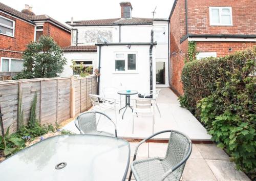 a patio with chairs and a table in a backyard at Modern House in Central Southampton with Private Off-Road Parking - Newly Refurbished - Great for Contractors, Friends & Families in Southampton