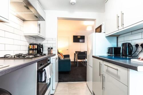 a kitchen with white cabinets and a counter top at Modern House in Central Southampton with Private Off-Road Parking - Newly Refurbished - Great for Contractors, Friends & Families in Southampton