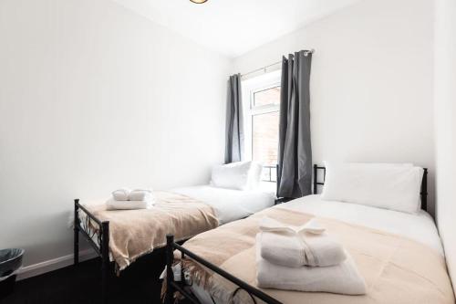 a bedroom with two beds and a window at Modern House in Central Southampton with Private Off-Road Parking - Newly Refurbished - Great for Contractors, Friends & Families in Southampton