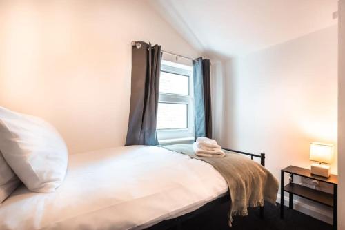 a bedroom with a bed with a window at Modern House in Central Southampton with Private Off-Road Parking - Newly Refurbished - Great for Contractors, Friends & Families in Southampton
