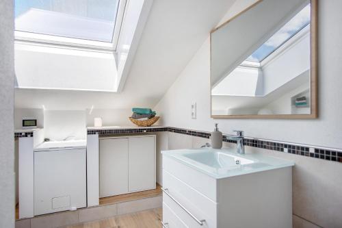 a white bathroom with a sink and a mirror at Im Spatzennest in Inzell