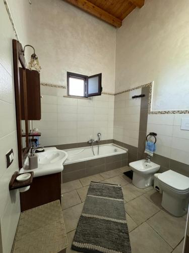 a bathroom with a tub and a toilet and a sink at Desiree Casa Vacanze in Avola