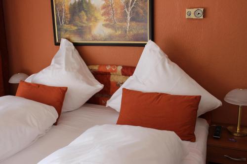 a bedroom with a bed with pillows and a picture on the wall at Legend Hotel in Biebesheim