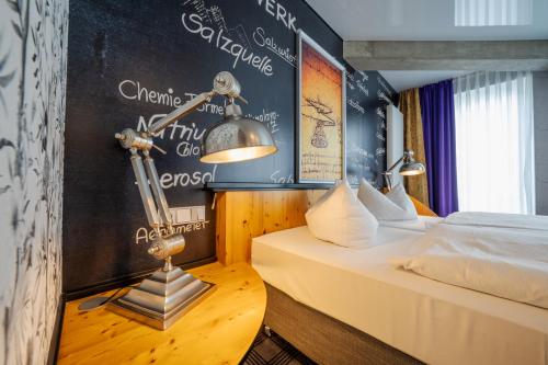 1 dormitorio con 2 camas y pared de pizarra en Hotel Solthus am See, en Baabe
