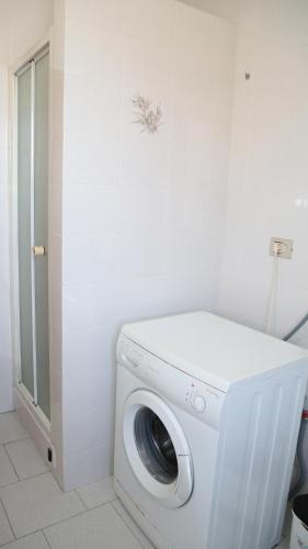 a washer and dryer in a white bathroom at Guest House Gobetti in Reggio Emilia