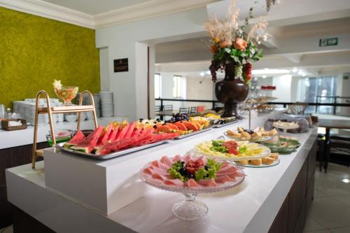 a buffet with many plates of food on a table at Havana Palace Hotel in Uberaba