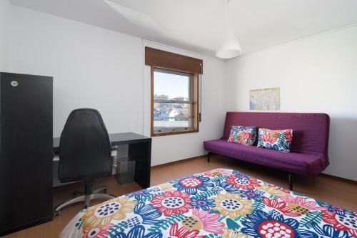 ポルトにあるVale Formoso Guest Houseのベッドルーム(ベッド1台、紫色のソファ付)