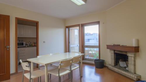 uma cozinha com uma mesa e cadeiras e uma lareira em Vale Formoso Guest House em Porto