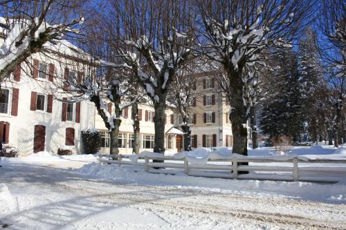 a fence covered in snow in front of a building at Best Western Grand Hotel de Paris & Spa in Villard-de-Lans