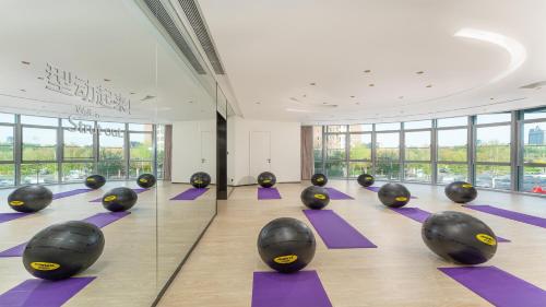 a yoga class with purple mats in a room with windows at EVEN Hotel Yinchuan Yuehai by IHG in Yinchuan