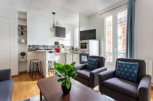 een woonkamer met een tafel en stoelen en een keuken bij 678 Suite Raspail - Superbe Appartement in Levallois-Perret