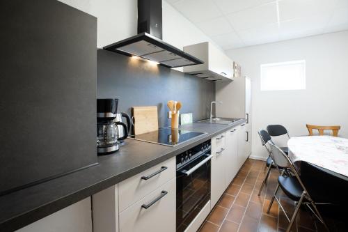 a kitchen with white cabinets and a black counter top at Wäller Garten in Westerburg