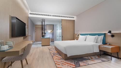 a hotel room with a large bed and a desk at EVEN Hotel Yinchuan Yuehai by IHG in Yinchuan