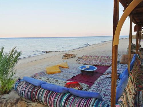 a beach with a blanket and a table on the beach at Sayal Camp in Taba