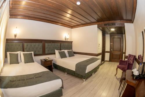 a bedroom with two beds and a wooden ceiling at Bursa Grand Family HOTEL in Bursa