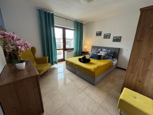 a bedroom with a yellow bed and a yellow chair at Zakopane - Apartament Chomikówka in Zakopane