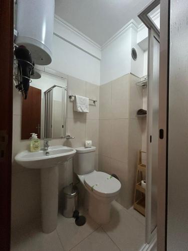 a bathroom with a toilet and a sink at Palmar Rooms in Funchal