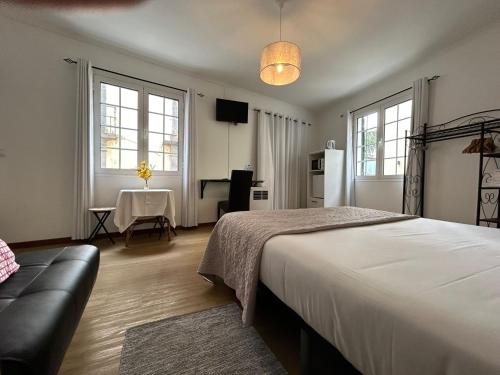 - une chambre avec un lit, une table et des fenêtres dans l'établissement Palmar Rooms, à Funchal