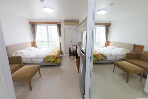 a bedroom with two beds and a table and chairs at Condo I-House Laguna Garden RCA - Behind Sukhumvit Thonglor Asoke Emporium Bangkok Hospital Piyavet Hospital Makkasan Airport Link MRT SKY TRAIN in Bangkok