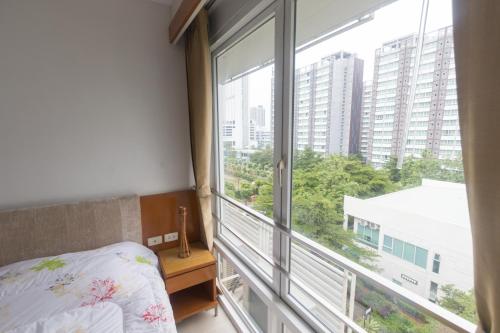 a bedroom with a bed and a large window at Condo I -House Laguna Garden RCA - Behind Sukhumvit-Outer CBD in Bangkok