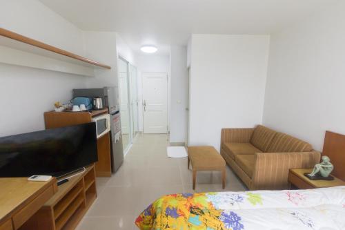 a room with a bed and a couch and a television at Condo I-House Laguna Garden RCA - Behind Sukhumvit Thonglor Asoke Emporium Bangkok Hospital Piyavet Hospital Makkasan Airport Link MRT SKY TRAIN in Bangkok