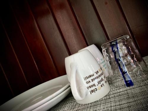 a cup and a glass jar sitting on a table at Lotus Haven Villa in Siem Reap
