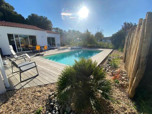une cour arrière avec une piscine et une terrasse en bois dans l'établissement Villa Les Sables Vigniers, à Les Sables Vignier