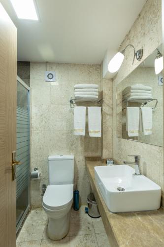 a bathroom with a white toilet and a sink at Bursa Grand Family HOTEL in Bursa