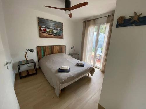 une chambre avec un lit et un ventilateur de plafond dans l'établissement Villa Les Sables Vigniers, à Les Sables Vignier