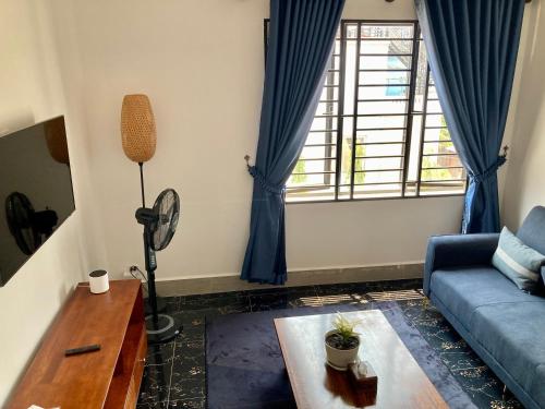 a living room with a blue couch and a table at Lotus Haven Villa in Siem Reap
