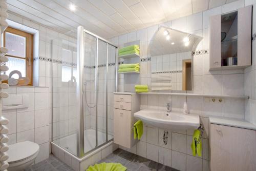 a white bathroom with a sink and a shower at Ferienhof 'beim Wendlar' in Bad Hindelang
