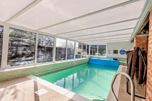 an indoor swimming pool in a building with windows at Starling cottage in Pickering