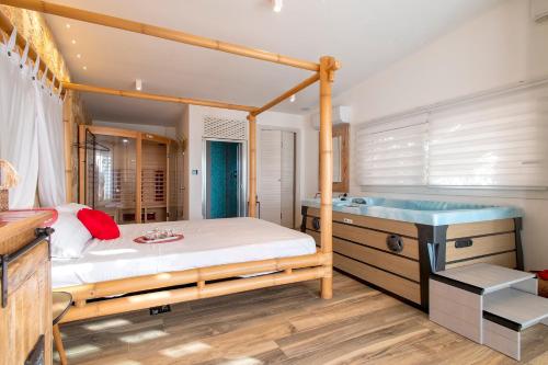a bedroom with a canopy bed and a tub at Residenza alla Collina & Romantic SPA in Porto Conte