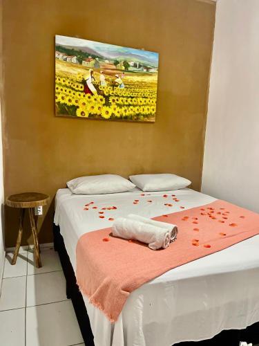 a bedroom with a bed with red rose petals on it at Pousada Meu Xodó in Jericoacoara