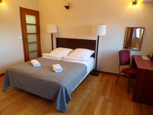 a bedroom with a bed with two towels on it at Open Doors Villa in Gdańsk